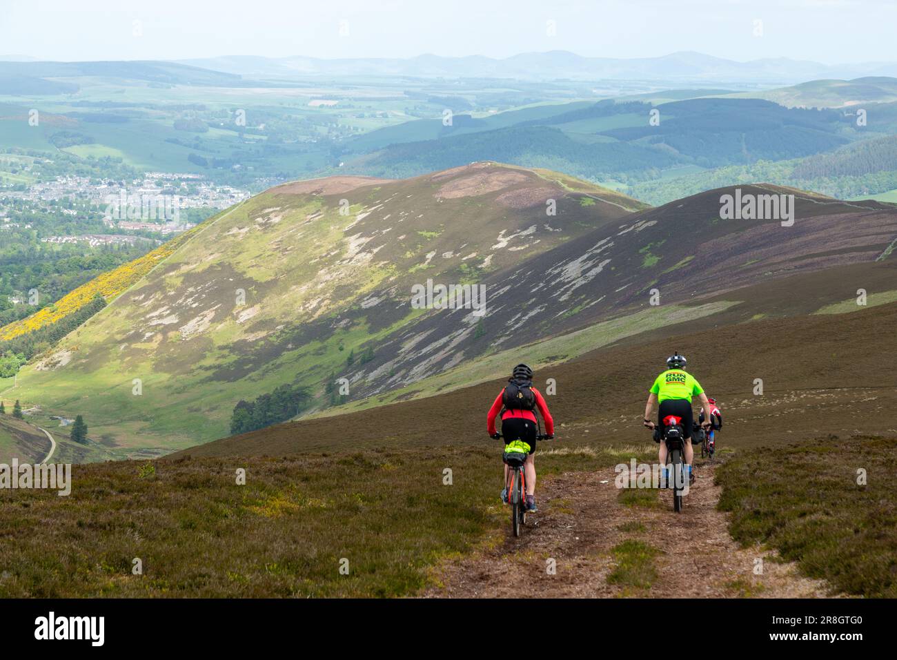 Gli appassionati di mountain bike si dirigono in discesa verso Peebles e Craig Head Hill, a Glensax Foto Stock