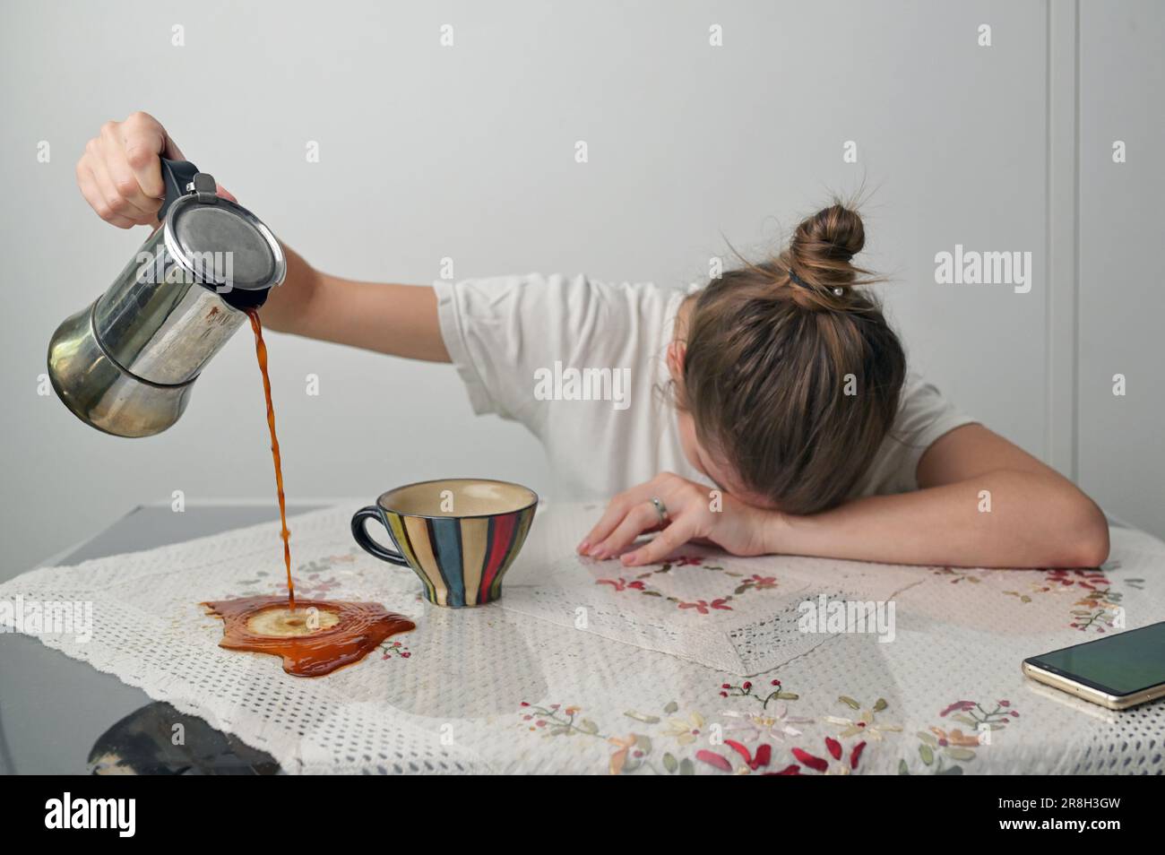 Concetto stanco giovane donna che ha privazione di sonno e caffè versante. Foto Stock