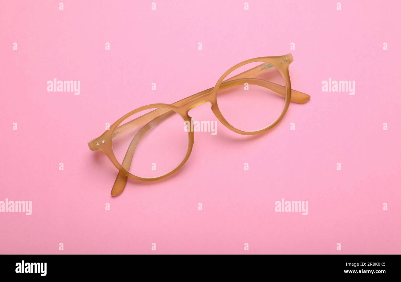 Occhiali con lenti correttive su sfondo rosa, vista dall'alto Foto Stock