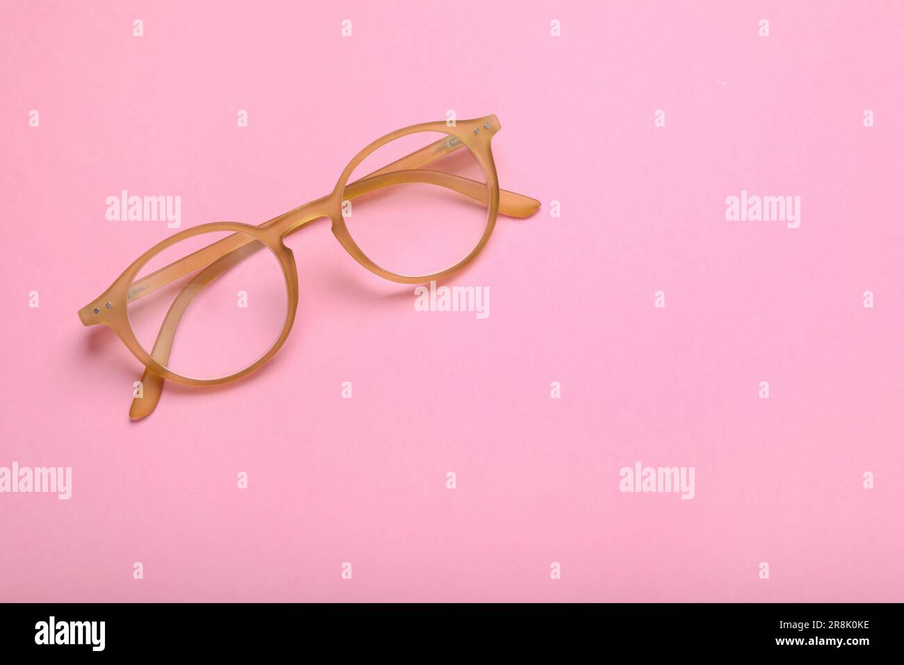Occhiali con lenti correttive su sfondo rosa, vista dall'alto. Spazio per il testo Foto Stock