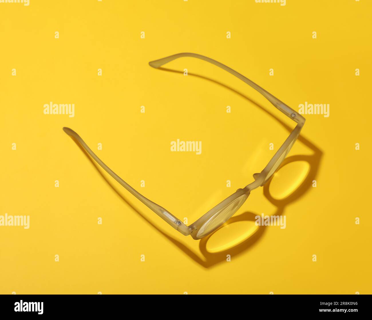 Occhiali con lenti correttive su sfondo giallo, vista dall'alto Foto Stock