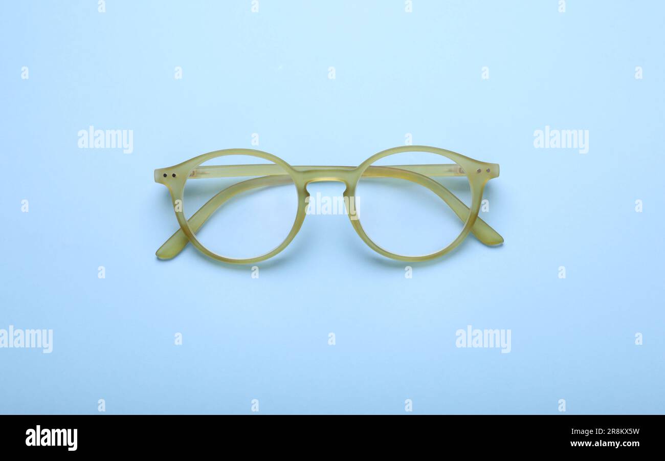 Occhiali con lenti correttive su sfondo azzurro, vista dall'alto Foto Stock
