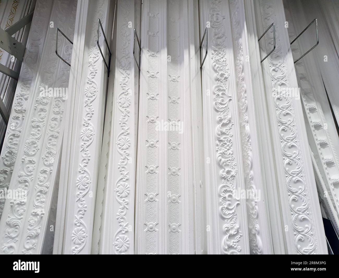 cornici per soffitto, diversi tipi di modanature per soffitto in plastica espansa bianca presso la vetrina del negozio, esempi di stand dimostrativi, showroom Foto Stock