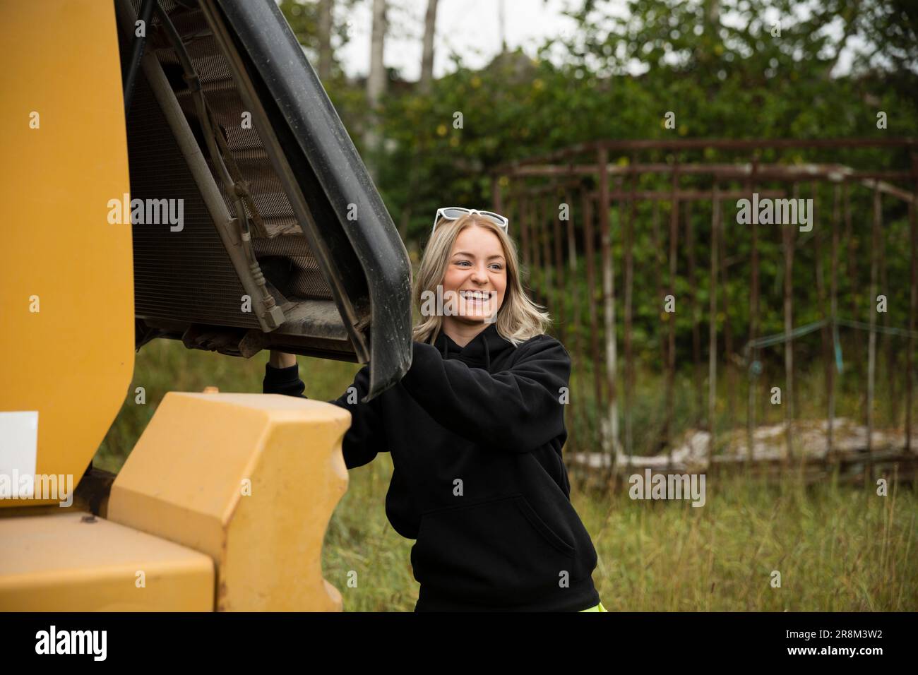 Giovane donna sorridente che chiude il bagagliaio Foto Stock