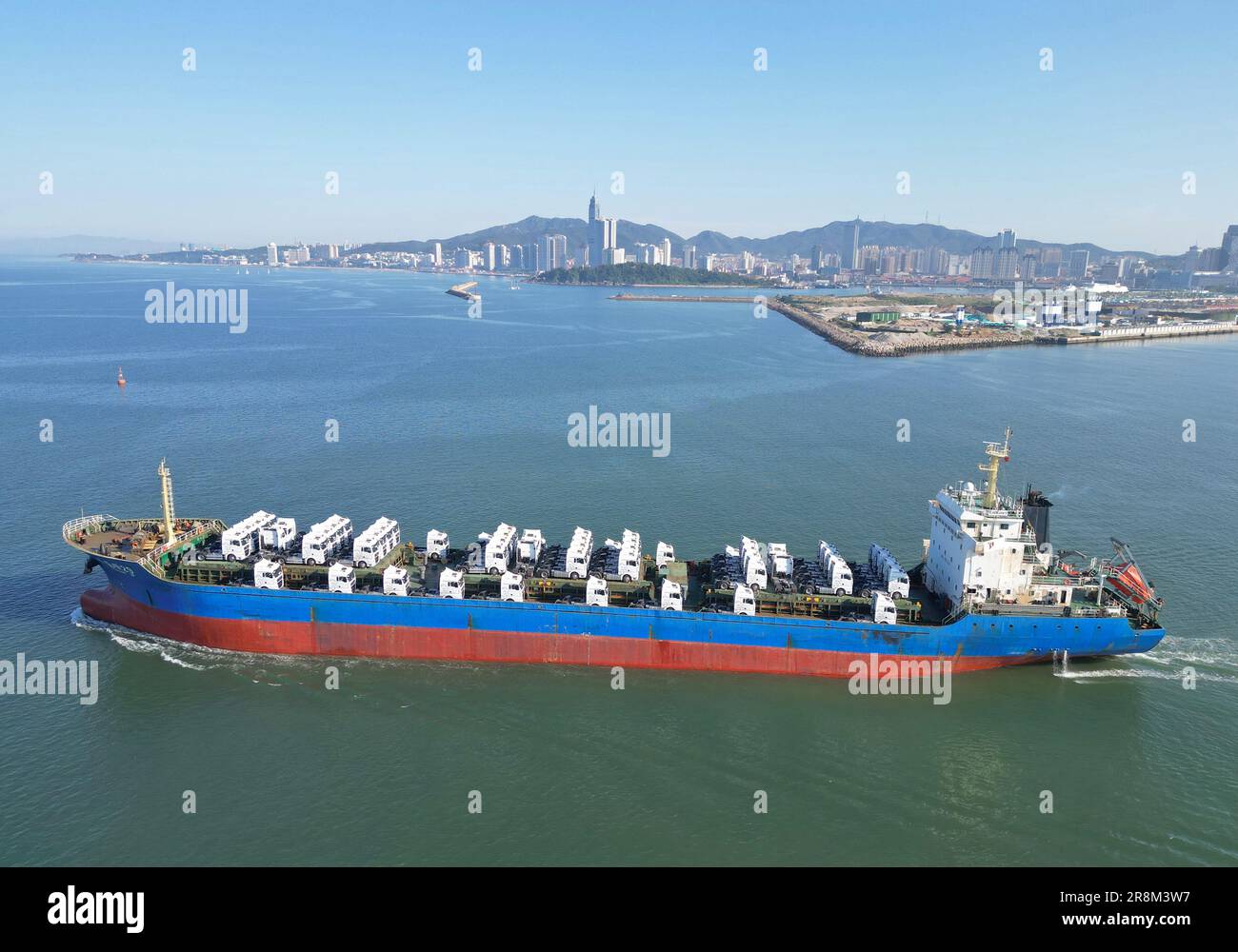 YANTAI, CINA - 21 GIUGNO 2023 - Una nave da carico caricata con autocarri pesanti cinesi lascia il porto di Yantai, provincia di Shandong, Cina, 21 giugno 2023. Foto Stock