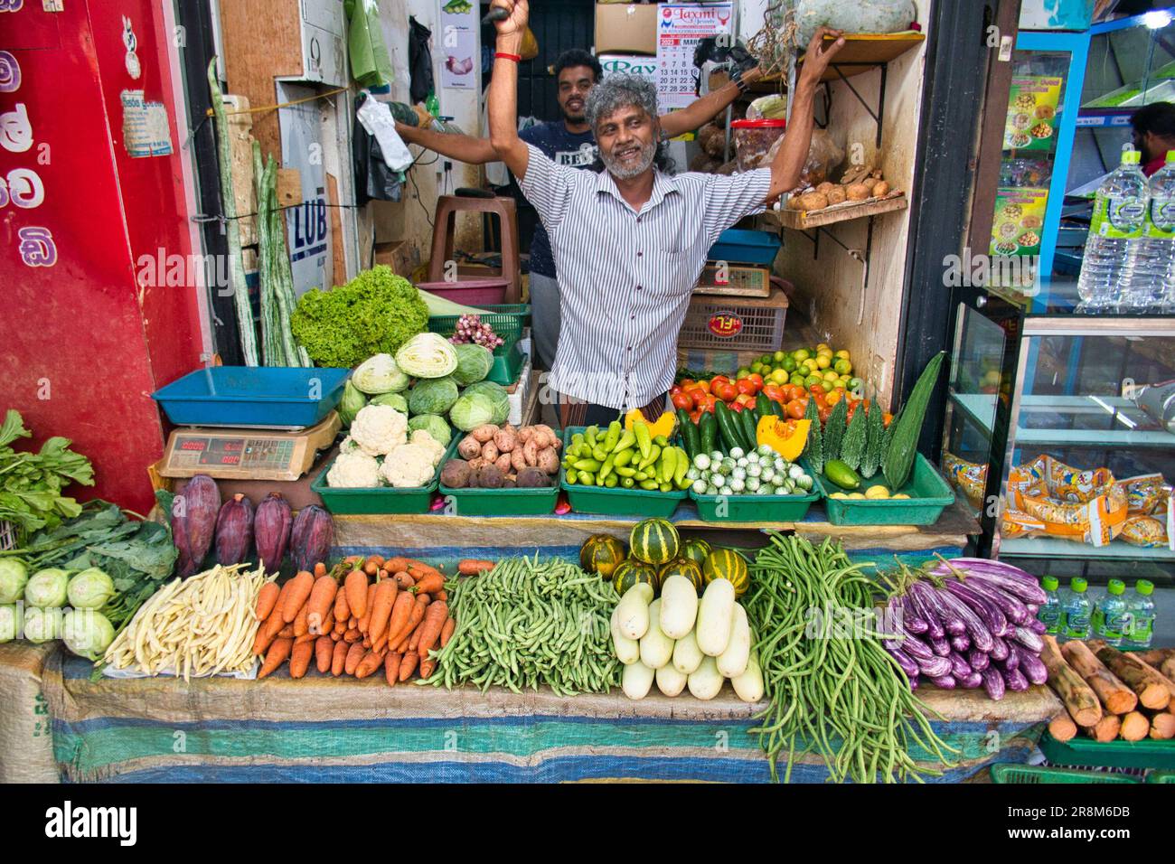 Frutta e verdura in vendita in un negozio a Kandy, nel centro dello Sri Lanka. Il personale è entusiasta del quadro. Foto Stock