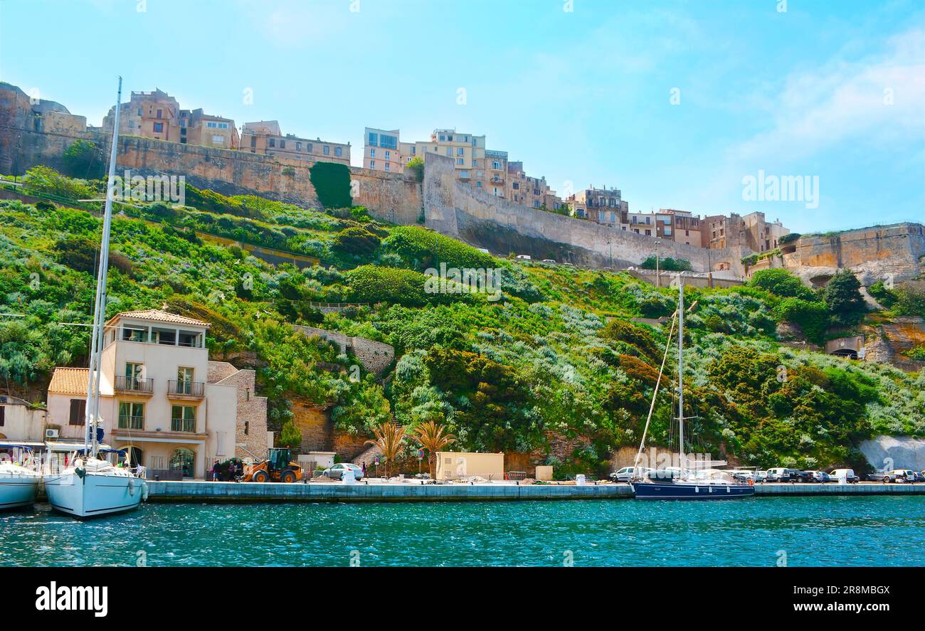 I bastioni medievali della Cittadella e le case storiche del centro storico dal porto di Bonifacio, Corsica, Francia Foto Stock