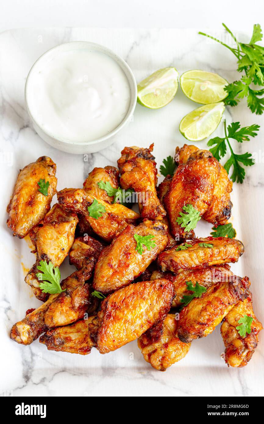 Ali di pollo al forno con salsa, popolare antipasto di pollo Foto Stock