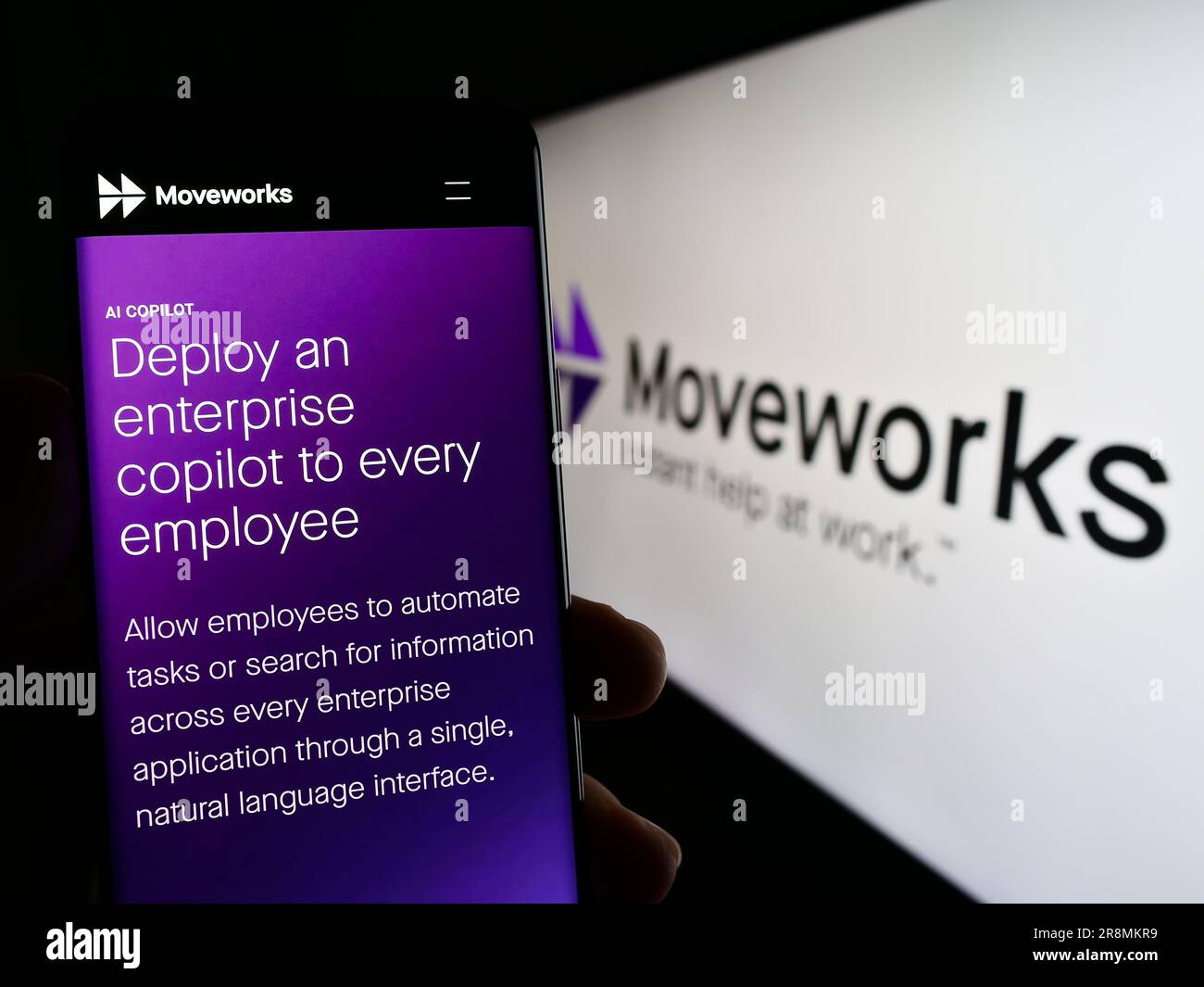 Persona che possiede uno smartphone con una pagina Web della società di intelligenza artificiale Moveworks Inc. Sullo schermo con logo. Concentrarsi sul centro del display del telefono. Foto Stock