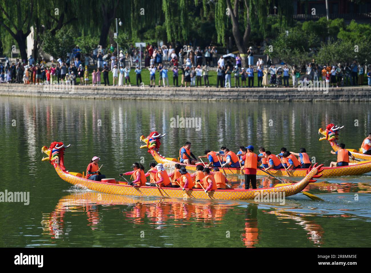 Pechino, Cina. 22nd giugno, 2023. La gente guarda una gara di draghi al Longtan Park a Pechino, capitale della Cina, 22 giugno 2023. Durante il Dragon Boat Festival si sono svolte qui una serie di attività, tra cui gare di barche, spettacoli e giochi interattivi. Credit: JU Huanzong/Xinhua/Alamy Live News Foto Stock