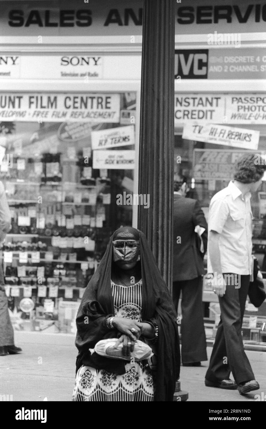 Arab Woman Earls Court Londra 1970s UK. La gente del Medio Oriente è venuta in Gran Bretagna per assistenza sanitaria sovvenzionata nelle cliniche di Harley Street. Sono stati principalmente in alberghi economici a Earls Court. Una signora araba che indossa una maschera Battoulah che solitamente indica che è sposata. Earls Court, Londra, Inghilterra circa 1977 70s HOMER SYKES Foto Stock