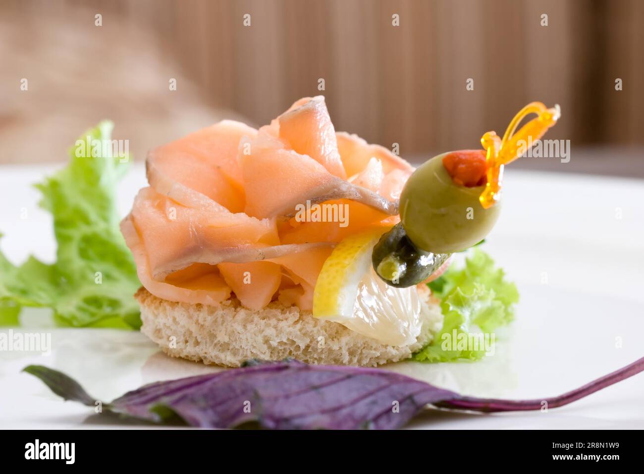 Una deliziosa canape di salmone affumicato con limone, cetriolo e oliva Foto Stock