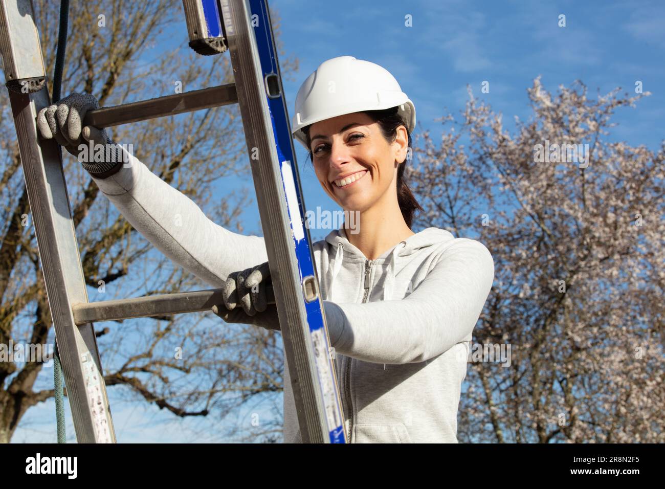 donna costruzione costruttore lavoratore che tiene una scala Foto Stock