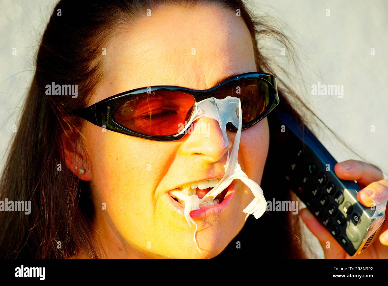 Donna con bolla di gomma scoppiata, gomma da masticare Foto Stock