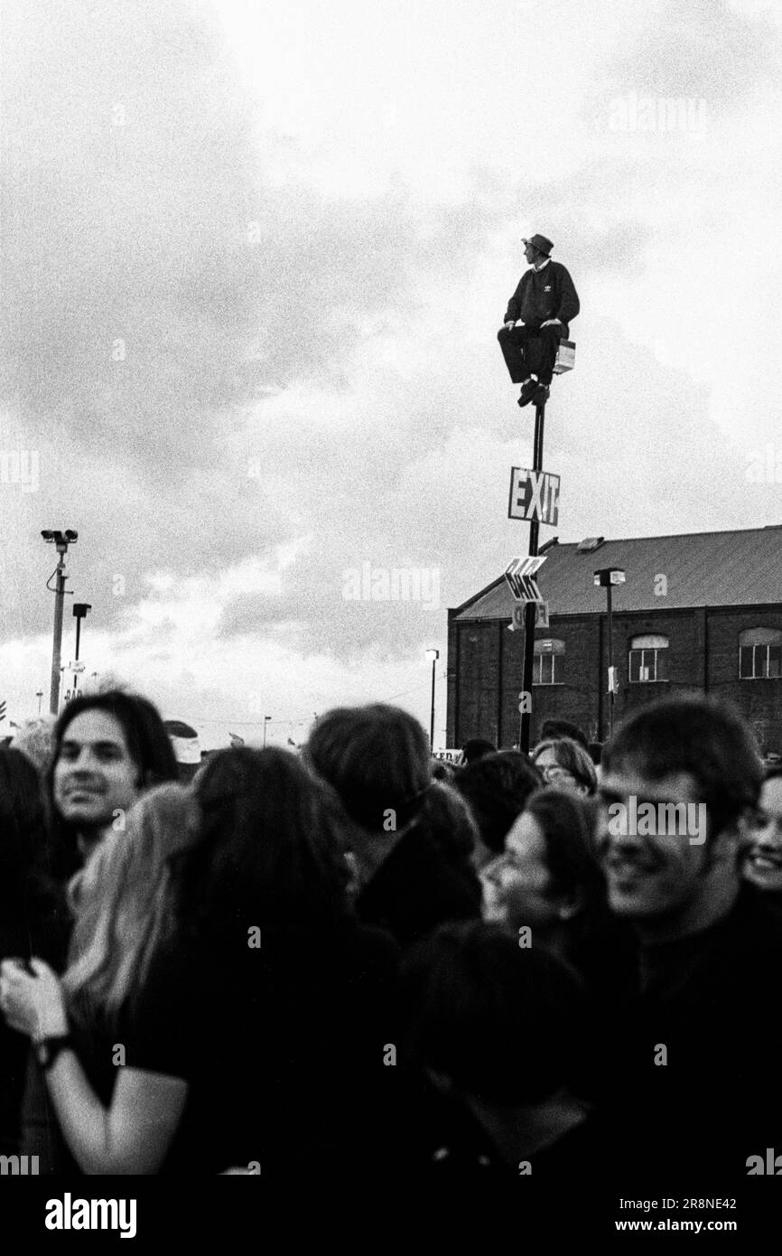 Un uomo in Galles, una maglietta di rugby sale un lampione per avere una visione migliore della folla al BBC Big Noise Festival di Cardiff Bay, Cardiff, Wales, UK domenica 11 maggio, 1997. Foto: Rob Watkins Foto Stock