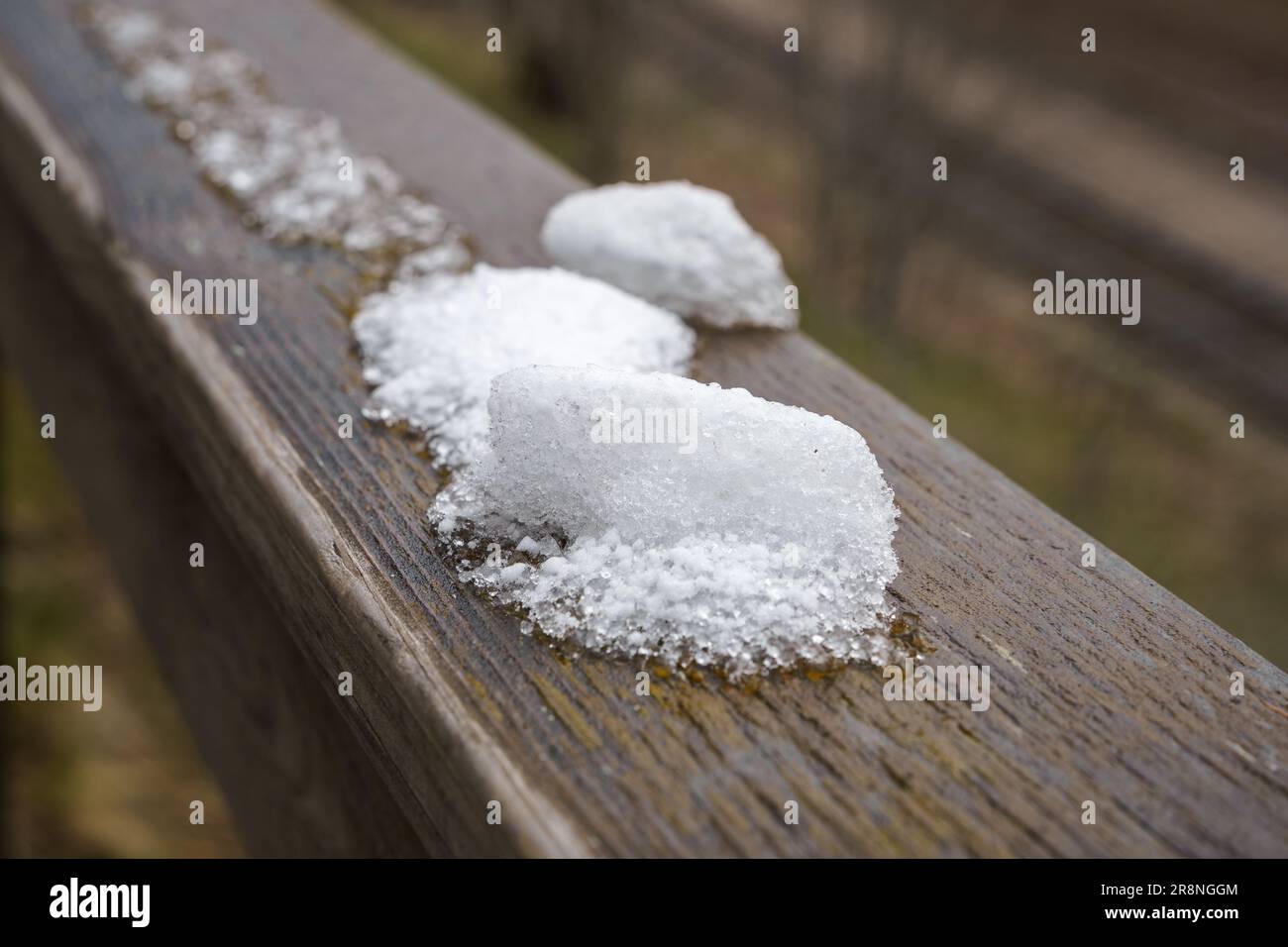 Chiazza di neve su un corrimano di legno, primo piano Foto Stock