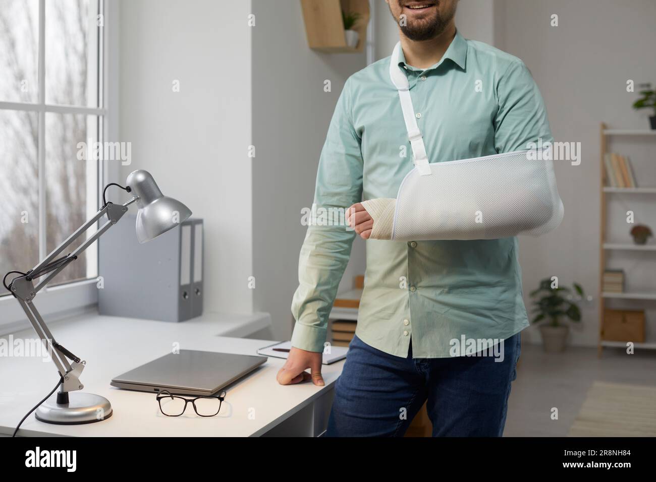 Foto ritagliata di un giovane uomo con braccio rotto nel gesso Foto Stock