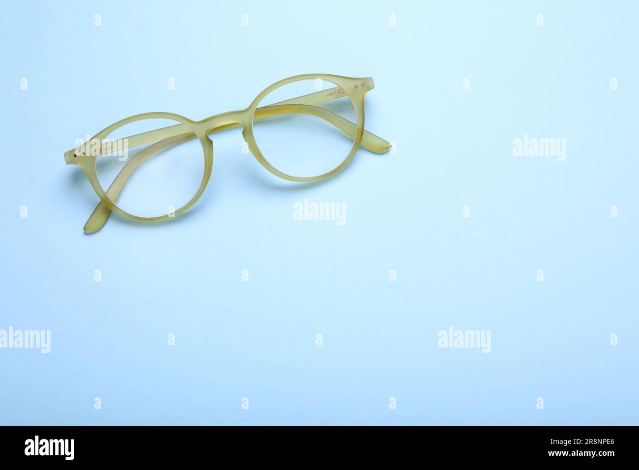 Occhiali con lenti correttive su sfondo azzurro, vista dall'alto. Spazio per il testo Foto Stock