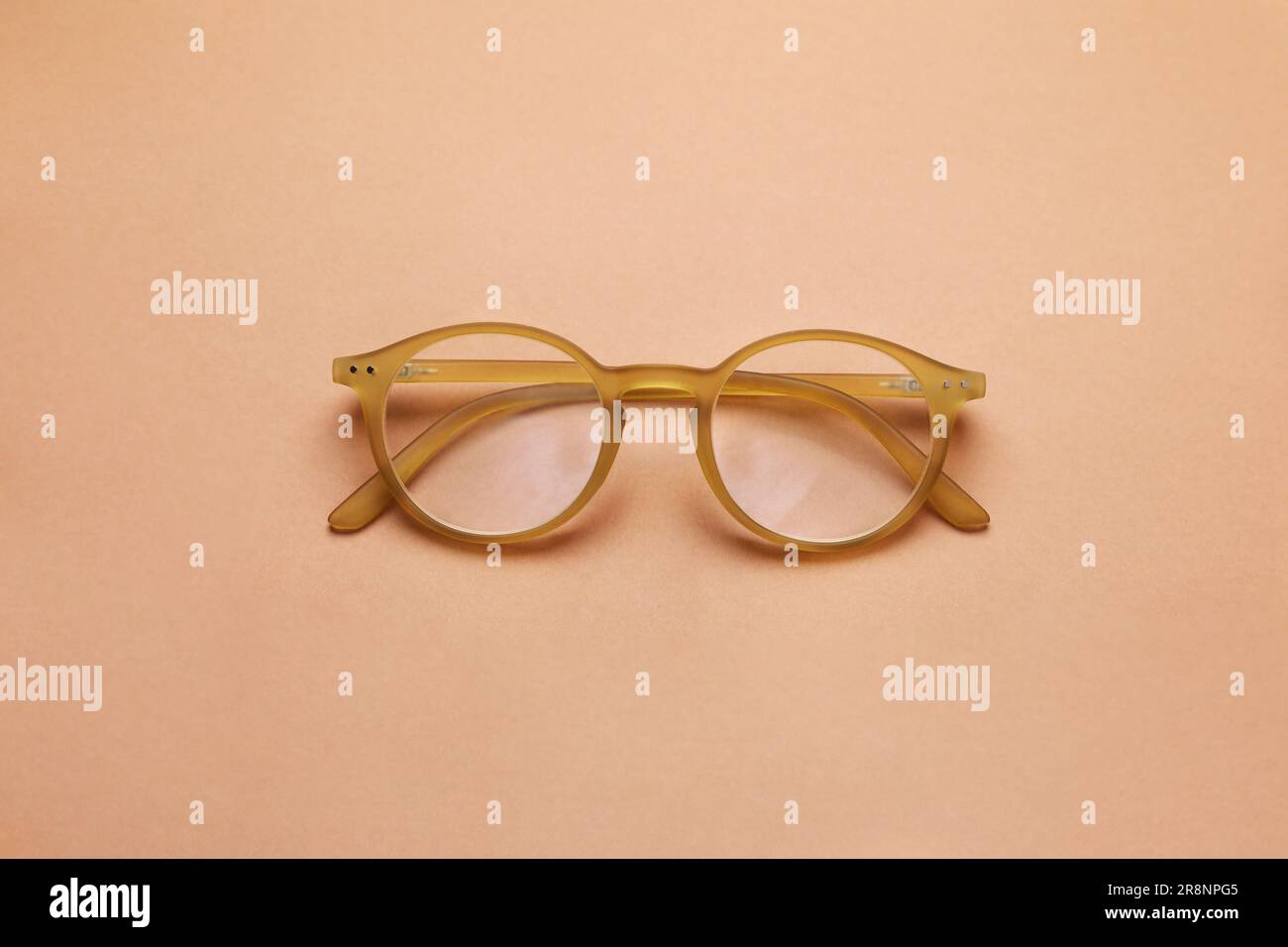 Occhiali con lenti correttive su sfondo marrone chiaro, vista dall'alto Foto Stock