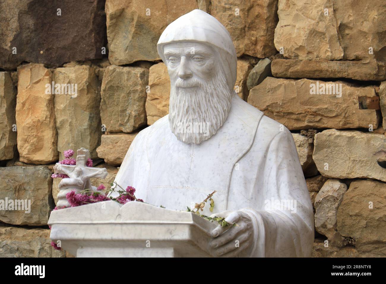 Una statua di Mar Charbel, il santo libanese, in possesso di un crocifisso. Foto Stock