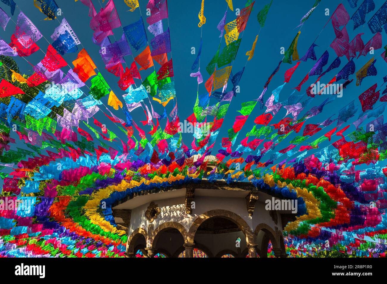 Bandiere di carta pecchiate sono viste attaccate alle linee e appese sopra la piazza con una bandstand durante il giorno dei morti festeggiamenti a Tlaquepaque, Messico. Foto Stock