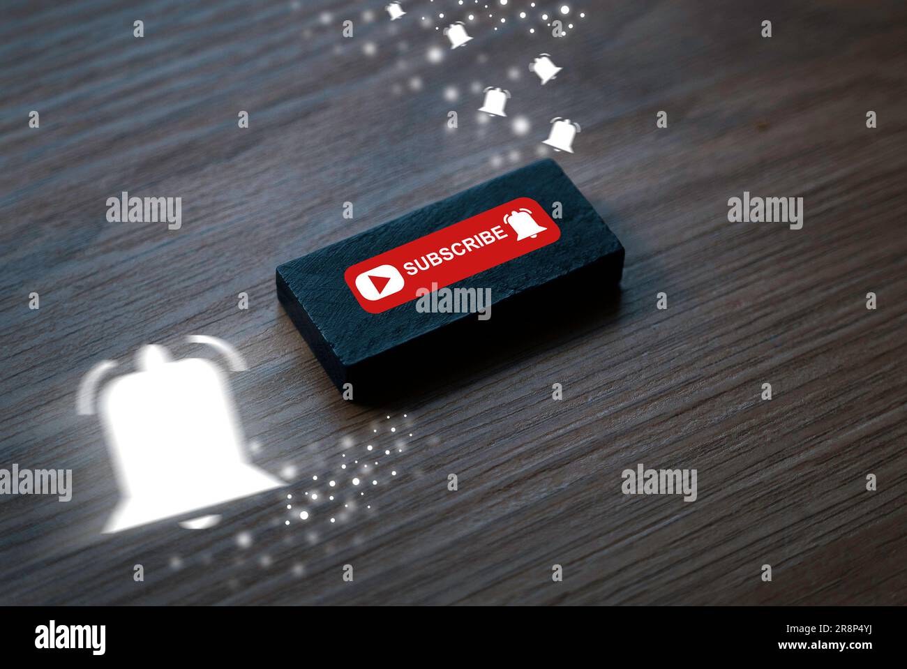 Bottone in legno con nota di iscrizione e icona della campana di notifica su sfondo in legno. Sfocatura del movimento della campana di notifica bianca. Concetto di social media e. Foto Stock