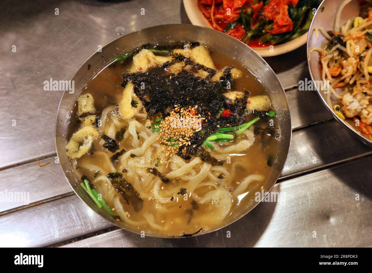 Cibo coreano a Seoul. Famosi spaghetti kalguksu nel mercato di Namdaemun Kalguksu Alley. Foto Stock