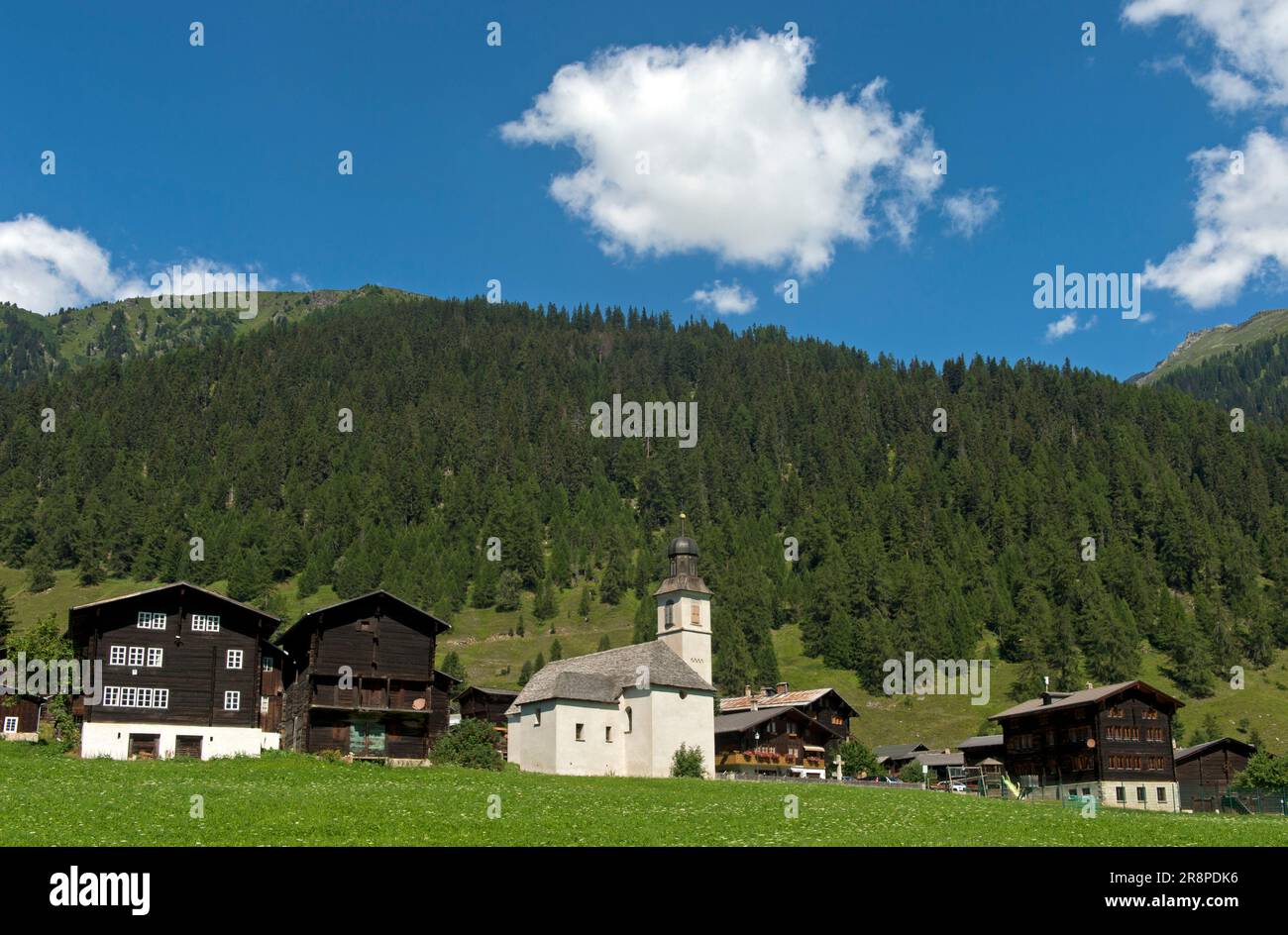 Vista sul villaggio con edifici residenziali, granaio e chiesa, Gluringen, Goms, Vallese, Svizzera Foto Stock