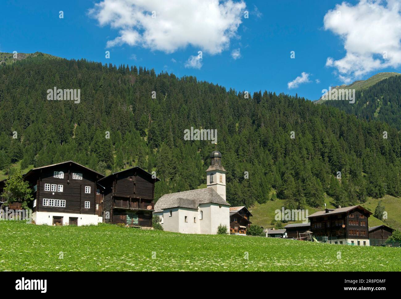 Vista sul villaggio con edifici residenziali, granaio e chiesa, Gluringen, Goms, Vallese, Svizzera Foto Stock