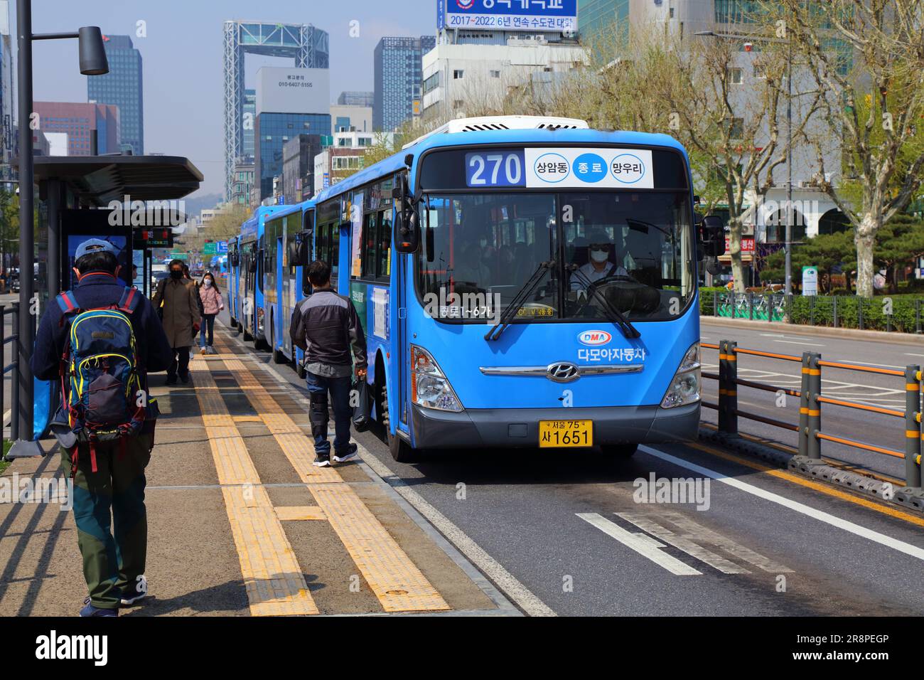 SEUL, COREA DEL SUD - 7 APRILE 2023: I passeggeri salgono a bordo di autobus urbani lungo Jong-ro Street nel quartiere Jongno di Seoul. Foto Stock
