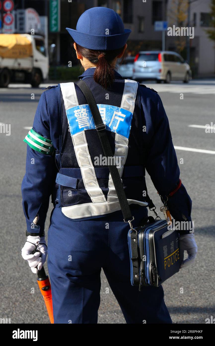 TOKYO, GIAPPONE - 30 NOVEMBRE 2016: Ufficiale di polizia femminile che regola il traffico nel distretto di Taito, città di Tokyo, Giappone. Foto Stock