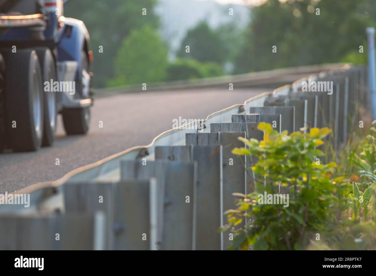 recinzione a bordo strada con sfondo sfocato del passaggio dei camion di carburante, risorse grafiche sfondi per il trasporto di risorse in luce naturale Foto Stock