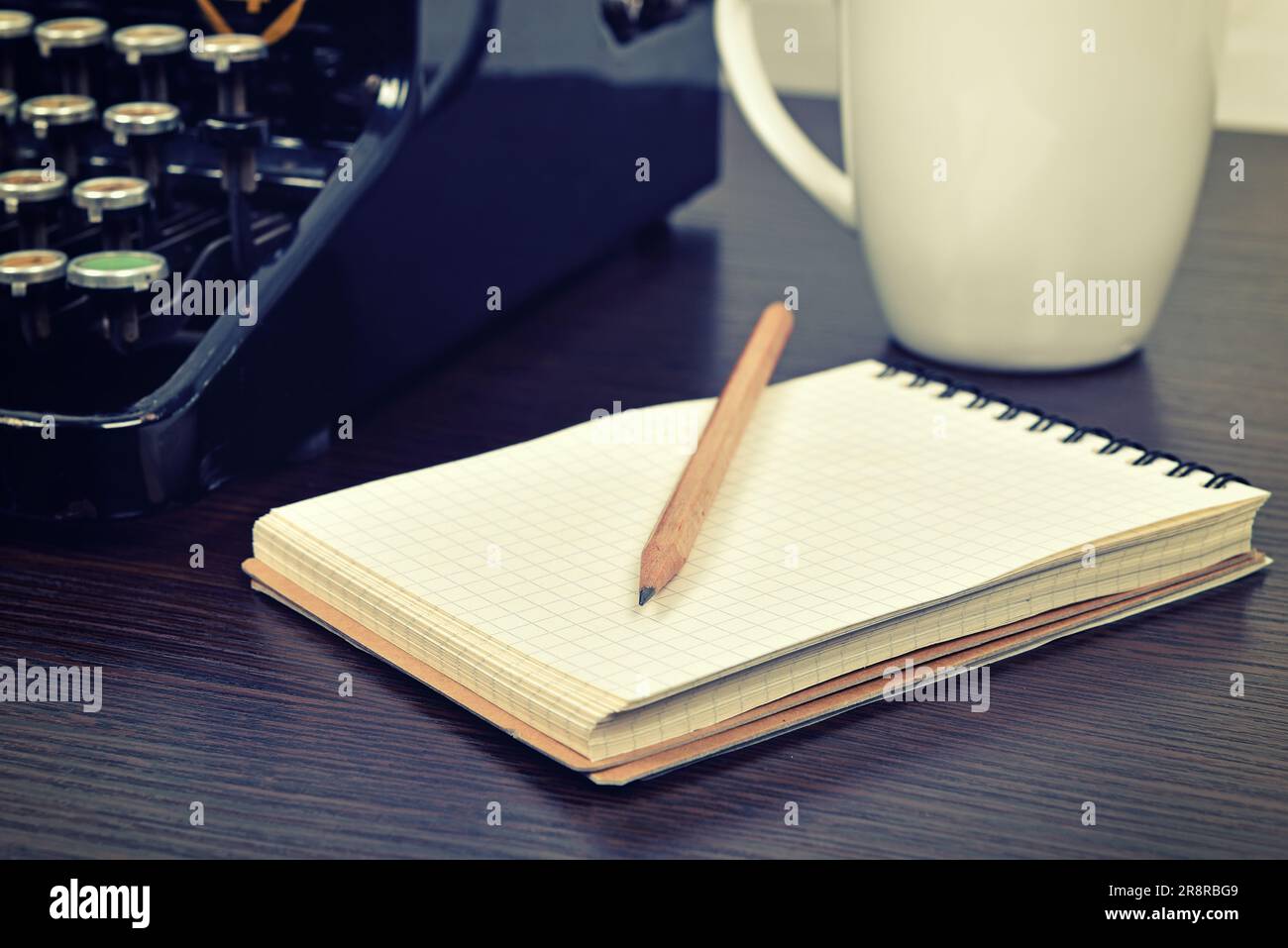 notebook vuoto, tazza e macchina da scrivere vintage sulla scrivania dello scrittore Foto Stock