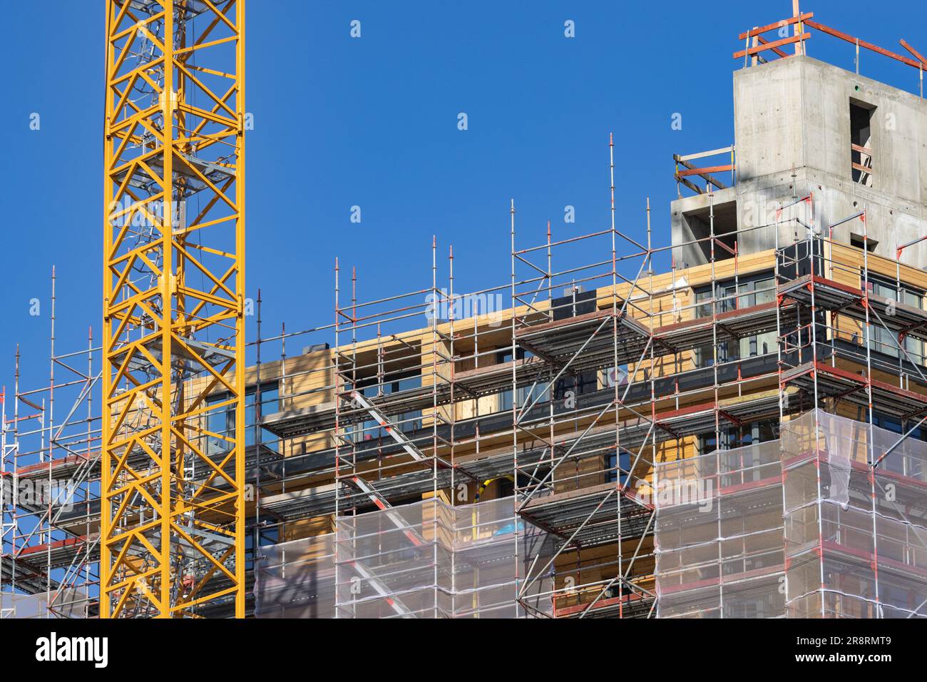 cantiere di un alto edificio in legno con una gru Foto Stock