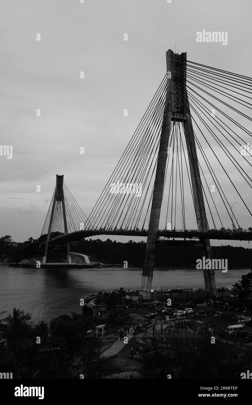 Un'accattivante cattura monocromatica da una prospettiva umana, che mostra la presenza imponente dell'iconico Ponte Barelang. Foto Stock
