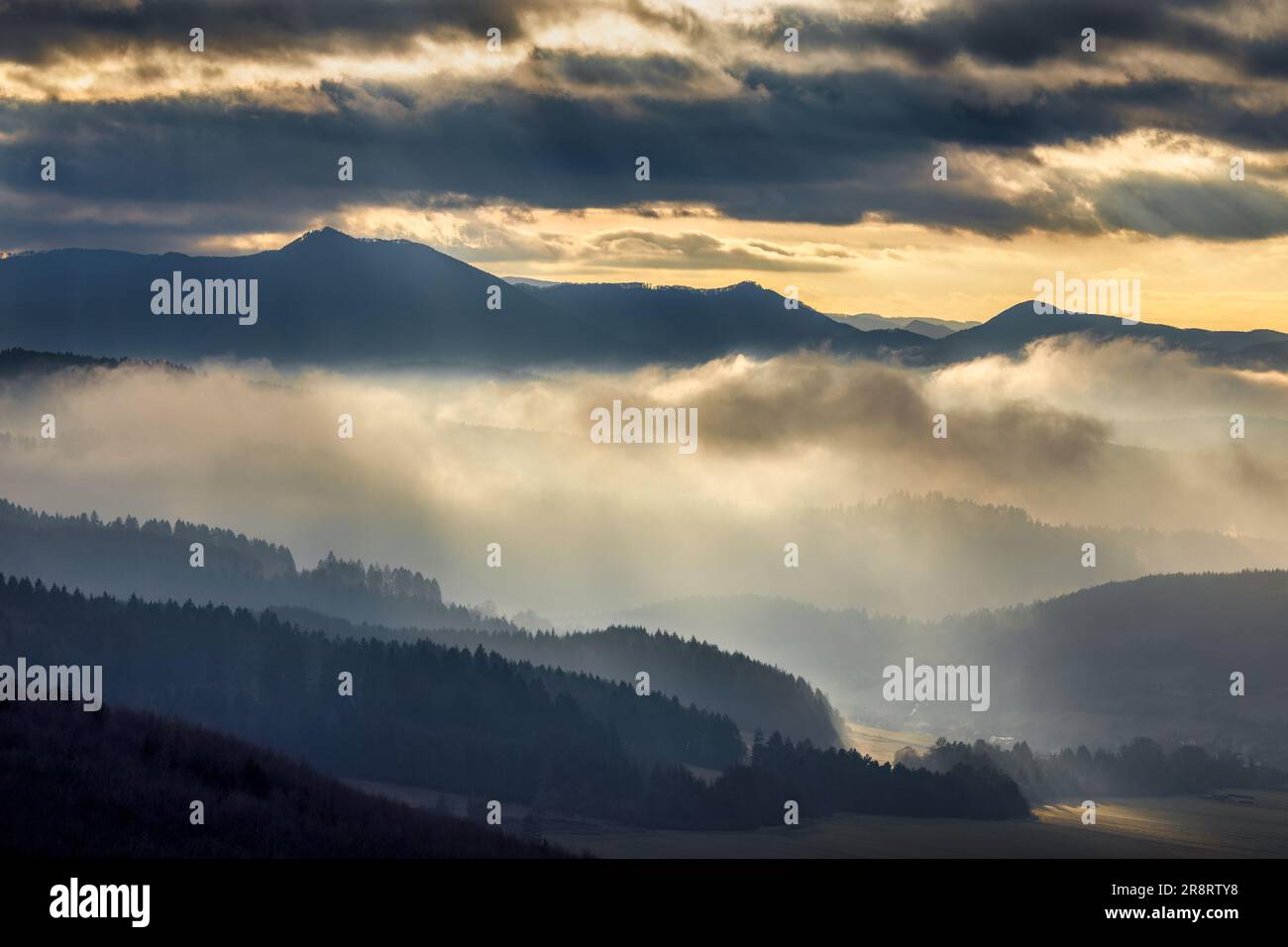 Paesaggio montuoso con valli nebbiose alla luce spettacolare del tramonto. Slovacchia nord-occidentale, Europa. Foto Stock