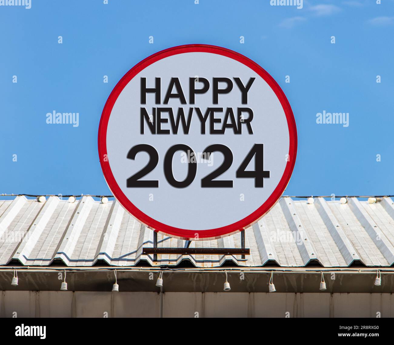 Un cartellone Circle con testo Happy New Year 2024 è installato su un tetto. Saluto per il nuovo anno. Foto Stock