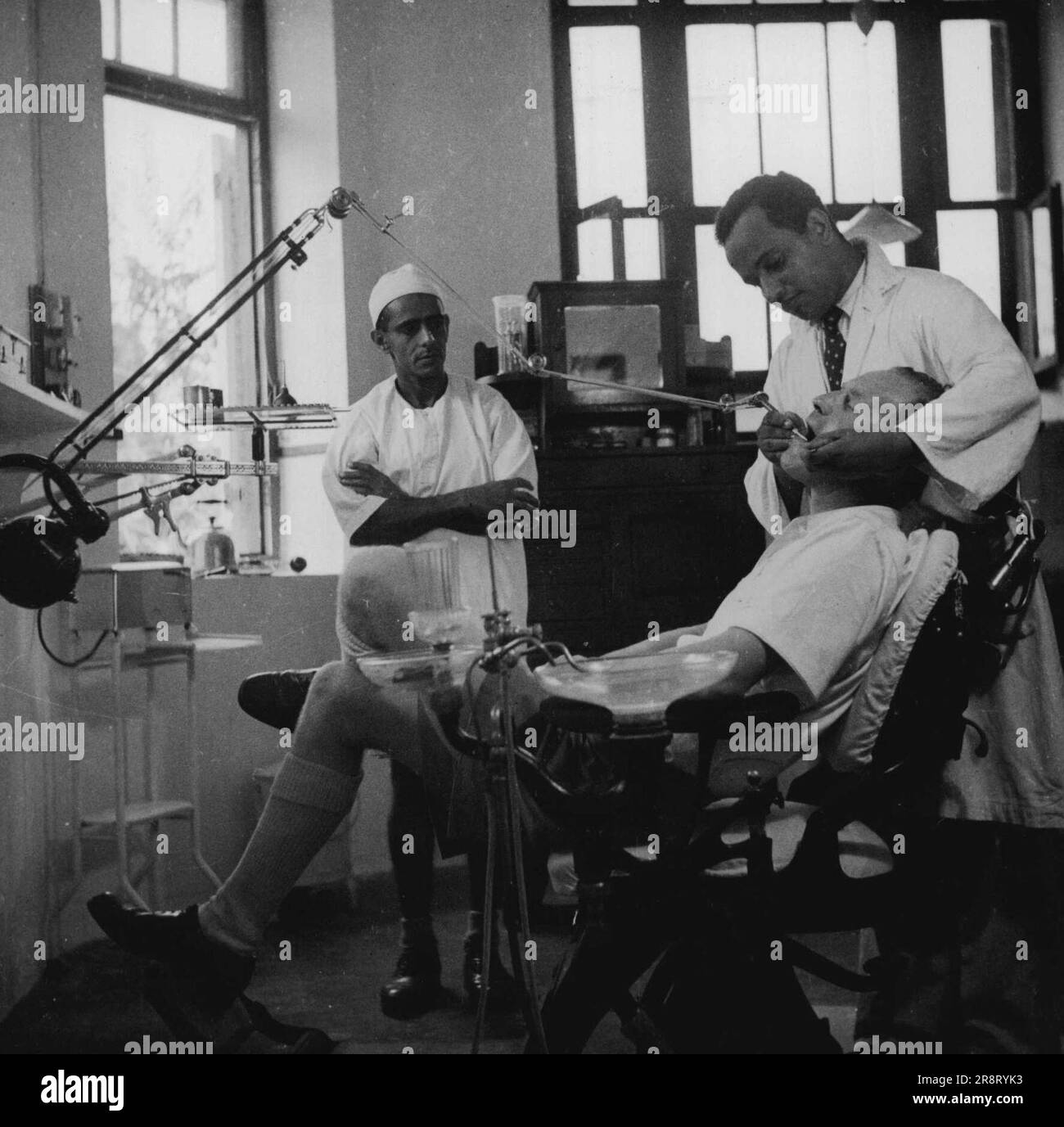 Dr. Soud Hohammed che è il chirurgo dentista aggiunto all'ospedale di Zanzibar. Zanzibar Arabo, è stato addestrato nella chirurgia dentale all'università americana a Beirut. Sta lavorando su un paziente europeo. Settembre 19, 1951. (Foto di British Official photo). Foto Stock