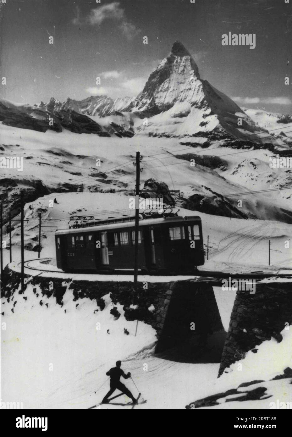 I treni semoventi consentono di ridurre i tempi di viaggio sulle Ferrovie svizzere -- il torreggiante Cervino fa da sfondo ad uno dei due nuovi treni semoventi messi in servizio sulla linea tra Zermatt e Cornergrath. Le carrozze, che trasportano 110 passeggeri, coprono la distanza in 45-50 minuti, 25 minuti in meno rispetto ai treni trainati da locomotive. Le nuove carrozze - le prime sono state introdotte sulla linea nel 1947 - costano circa 360.000 - franchi ciascuno. Aprile 21, 1952. Foto Stock