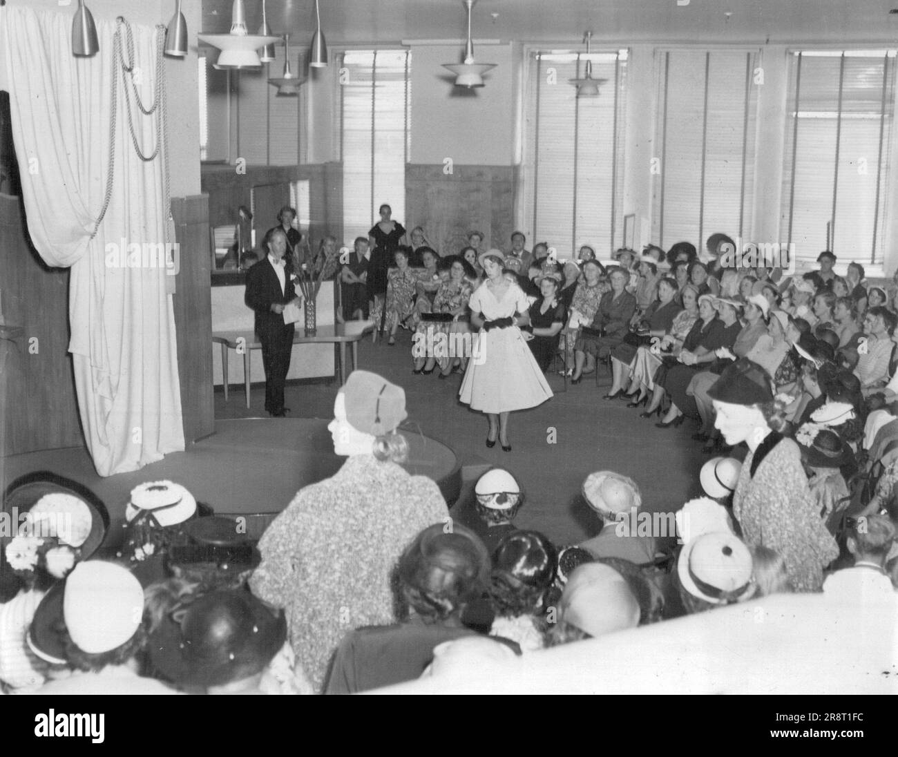 Gli spettacoli sono andati senza intoppi all'accompagnamento della musica e al suo commento di corsa a beneficio delle donne riunite. Marzo 10, 1954. Foto Stock
