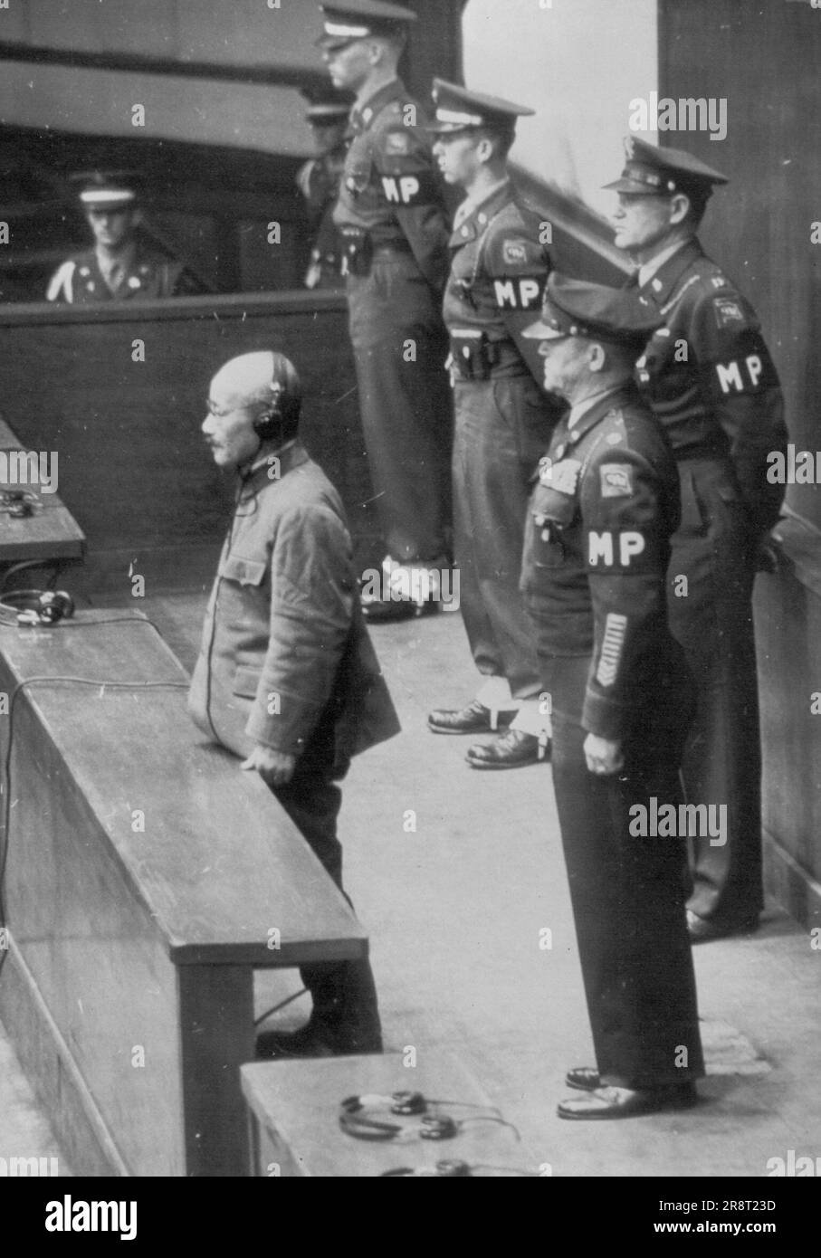 Sentenza passata -- Hideki Tojo, ex primo ministro del Giappone e leader di guerra è in piedi da solo in banchina come la sua sentenza è letta dal Tribunale militare Internazionale, Estremo Oriente a Tokyo Novembre 12. Sul retro si trova il Lt. Col. S.Kenworthy, responsabile dei prigionieri. Novembre 29, 1948. (Foto per foto stampa associata). Foto Stock