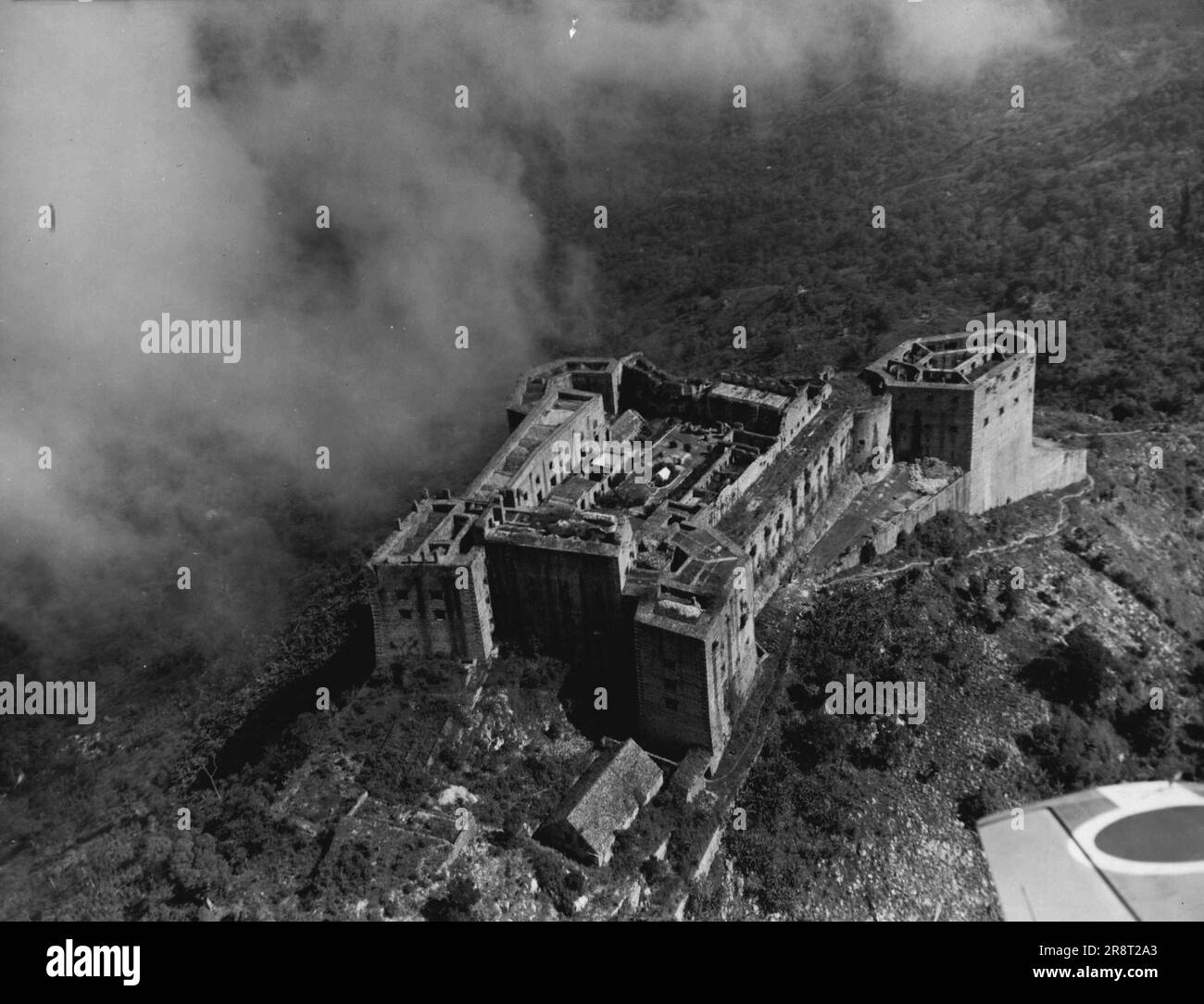 La Repubblica Nera - Haiti: Una delle attrazioni più notevoli del nuovo mondo - la cittadella di la Ferriere, nel nord di Haiti, costruita nel 1811-12 come palazzo, fortezza e caserma combinati dal re Enrico Christophe, la cui tomba è visibile come piccolo edificio bianco al centro del cortile centrale. La cittadella fu costruita con i lavori forzati. Fu qui che il re si sparò con un proiettile d'oro, fatto su suo ordine. 24 settembre 1949. (Foto di Alan Foley Pty. Ltd.). Foto Stock