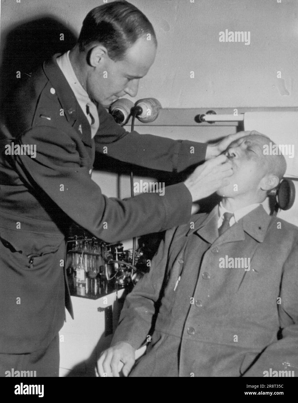 Tojo ottiene un controllo di salute -- Lt. F.X. Paul Tinker di Baltimora, Md., dà a Hideki Tojo, primo Ministro giapponese in tempo di guerra, un controllo della salute. Attualmente Tojo è in fase di processo sulle accuse penali in tempo di guerra. Novembre 06, 1946. (Foto di AP Wirephoto). Foto Stock