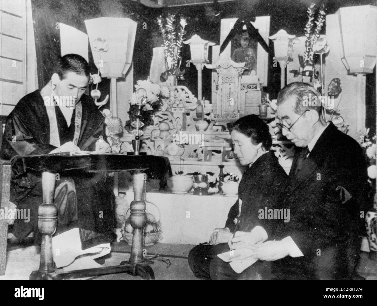 Servizi funebri per Tojo -- Shinso Hanayama (a destra), sacerdote buddista, presiede i servizi funebri privati per Hideki Tojo, uno dei sette giapponesi impiccati per crimini di guerra a Tokyo. Al centro c'è la vedova e a destra c'è Ichiro Kiyose, avvocato giapponese di Tojo. Hanayama amministrò gli ultimi riti e benedisse i corpi dei sette. Dicembre 26, 1948. (Foto di AP Wirephoto). Foto Stock