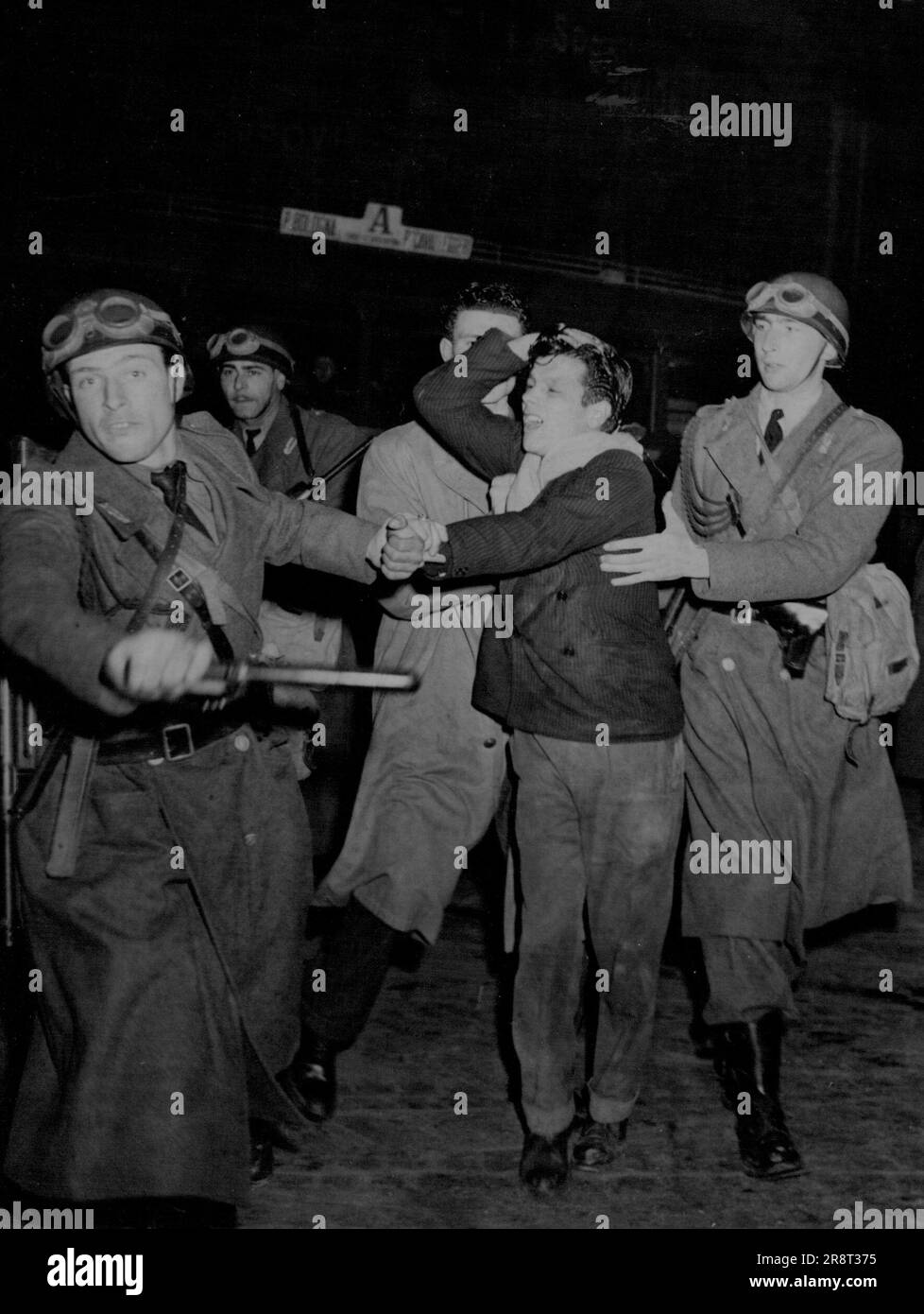 Sommosse a Roma sul Patto Atlantico -- un dimostrante "Anti-Patto", che tiene la testa a grappolo, viene portato via dalla polizia della squadra antisommossa, durante la manifestazione, il 12 marzo. L'annuncio alla camera dei deputati italiana della partecipazione di quel paese al previsto passato Atlantico ha dato luogo, il 12 marzo, ai peggiori disordini che Roma abbia conosciuto cantando il ***** dell'anno scorso. Circa 1.000 studenti che manifestavano in Piazza colonna, vicino al Parlamento, si rifiutarono di disperdersi per ordine della polizia. Le auto della polizia, armate di pistole tommy, accusarono la folla e circa una dozzina di persone rimasero ferite. 13 marzo… Foto Stock