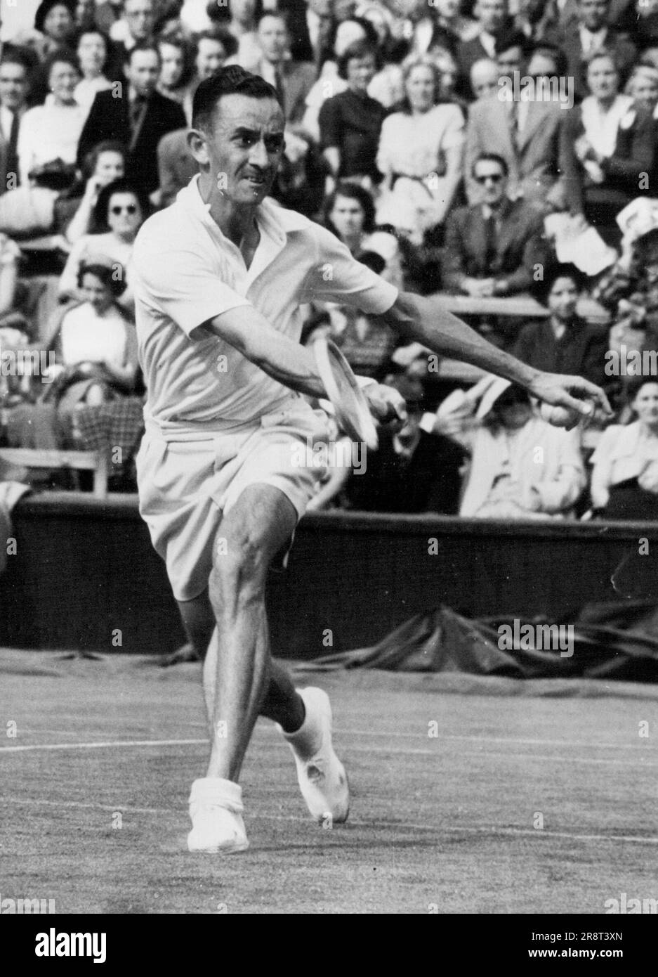 Sturgess esce - Sud Africa, E.W. Sturgess fa un ritorno di fronte a D.W. Candy, dell'Australia, durante il loro match di single di campo centrale nei campionati di tennis di Wimbledon, giocato all'All-England Club, Wimbledon. Giugno 27, 1951. Foto Stock