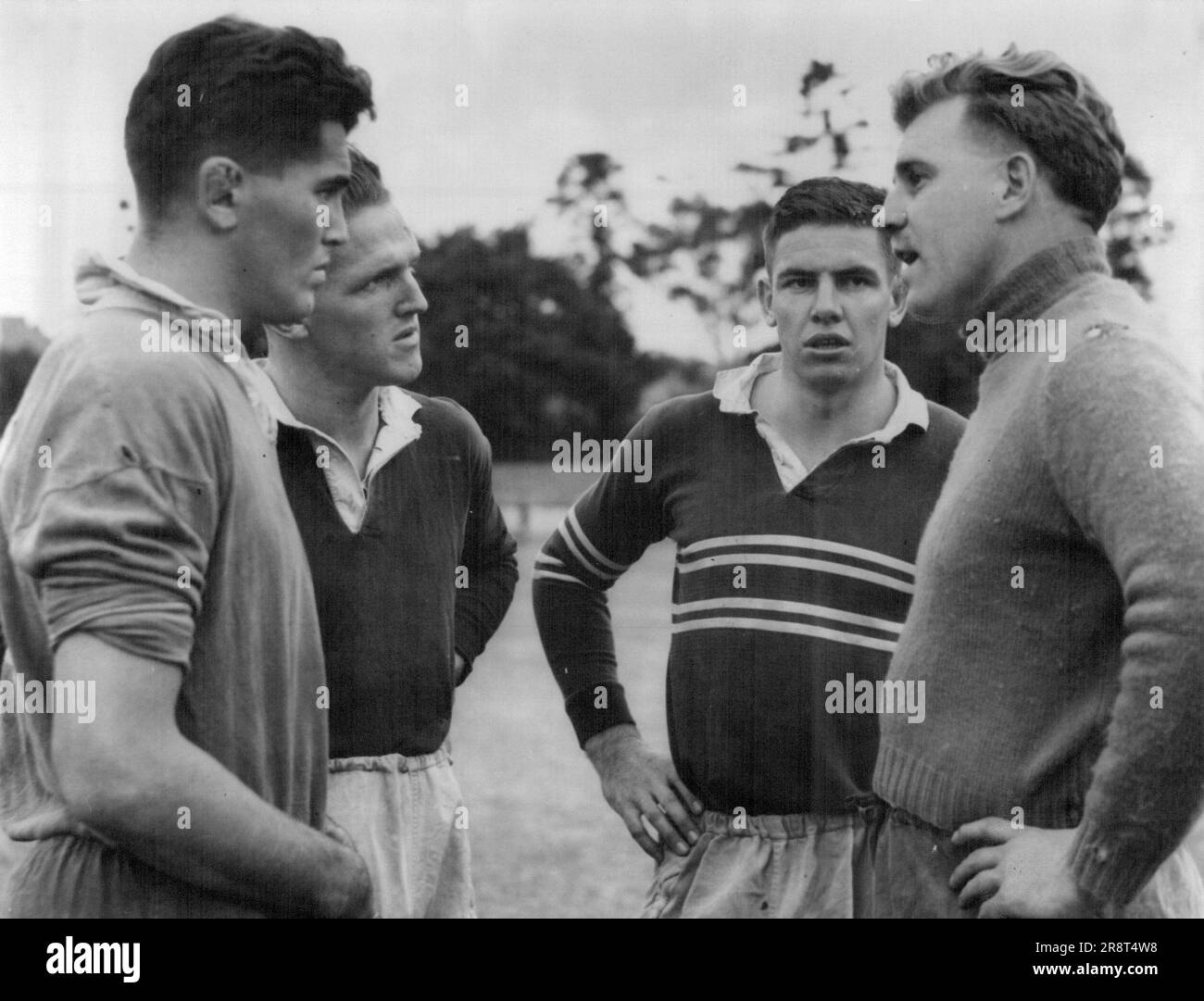 Allenatore 'Jika' Travers (a destra) ottiene una buona audizione come egli parla tattica per i avanti Rex Mosson, Doug Stewart e Ian McKellar, che giocherà per North Harbor contro Sud nella partita di Rugby Union di sabato a North Sydney Oval. 1 maggio 1951. Foto Stock