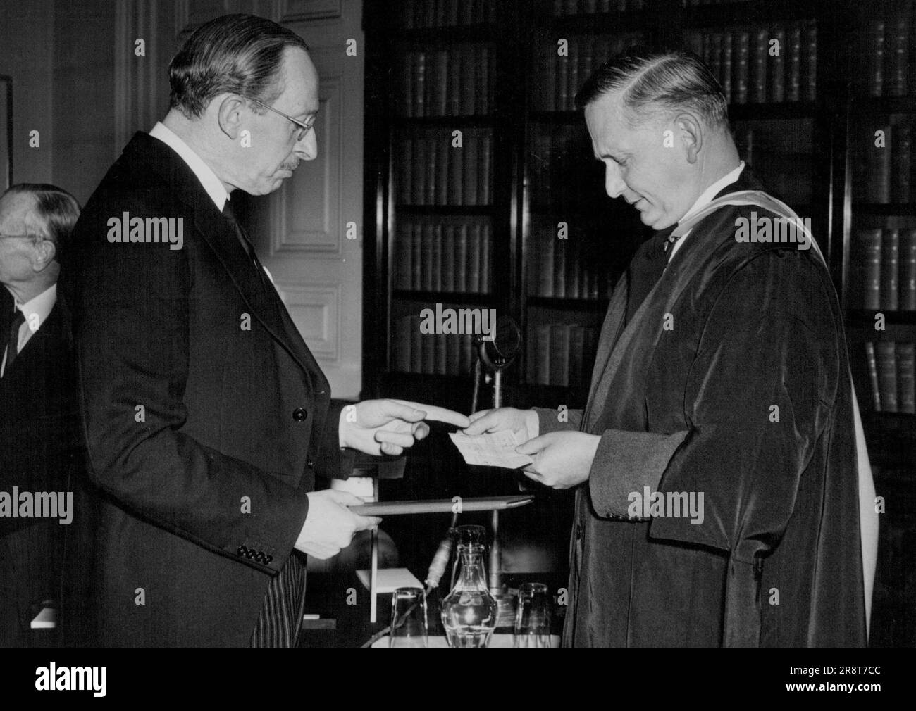 Il cancelliere dell'Università di Cambridge, Lord Tedder, riceve lo Smuts Memorial Fund volume da Lord Salisbury - Lord Salisbury, Segretario di Stato per le relazioni con il Commonwealth, presentando il volume dello Smuts Memorial Fund e assegno di £ 150.000 a Lord Tedder. Cancelliere dell'Università di Cambridge oggi. Nella stanza del Segretario di Stato al Commonwealth Relations Office a Downing Street questo pomeriggio, Lord, Salisbury, Segretario di Stato per le relazioni con il Commonwealth, ha consegnato a Lord Tedder, Cancelliere dell'Università di Cambridge. Un volume rilegato che commemora il defunto feldmaresciallo Smuts… Foto Stock