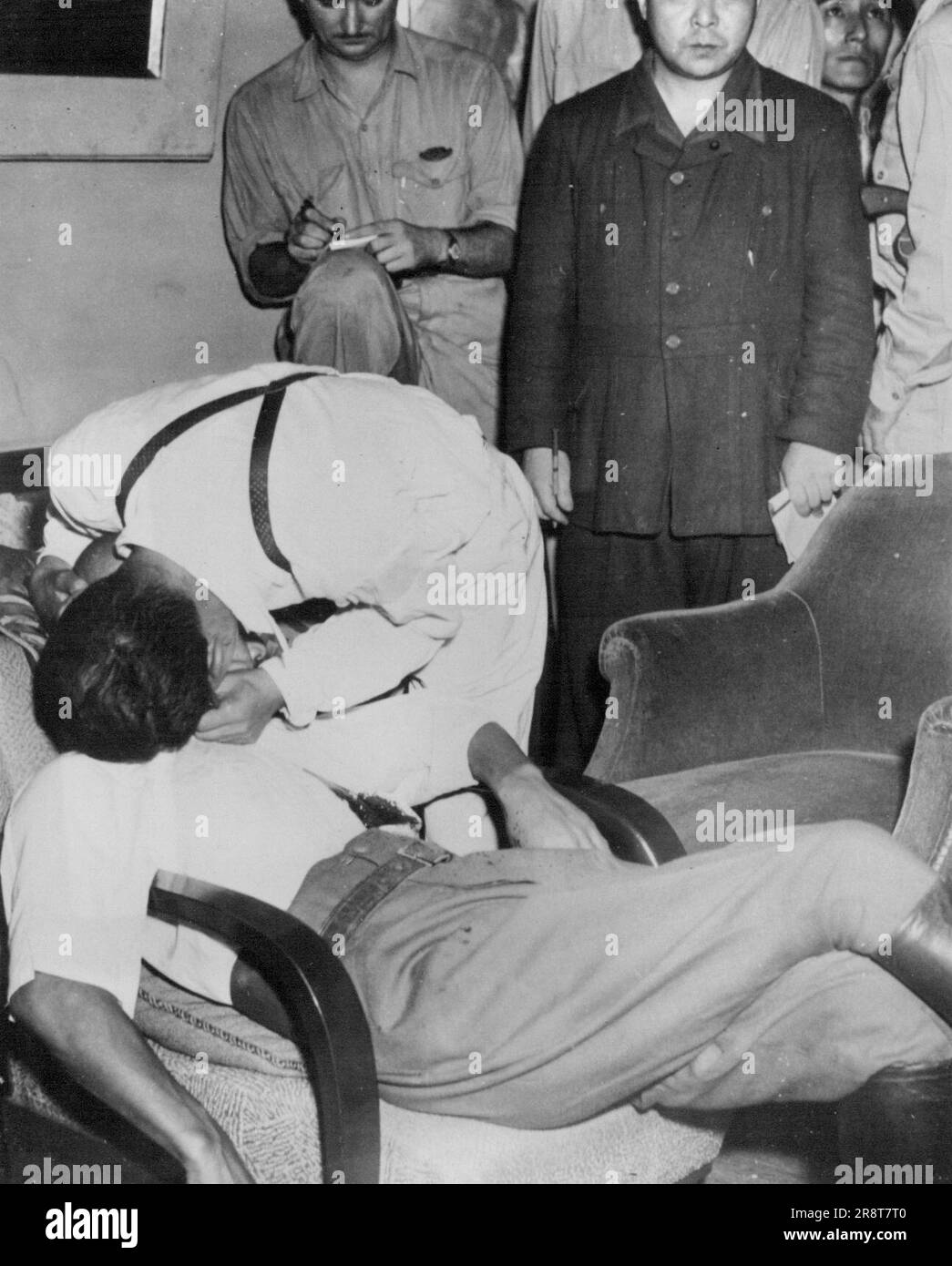 Affetto per Tojo? -- Un giapponese identificato come segretario di Tojo getta le braccia sul collo dell'ex Premier, che è stato gravemente ferito dopo un tentativo di suicidio. Tojo è stato trovato in una sedia nella sua casa, il sangue che sgorgava da una ferita gaping dopo che si è sparato nell'addome, da ufficiali americani che vengono ad arrestarlo. Settembre 16, 1945. (Foto di ACME). Foto Stock