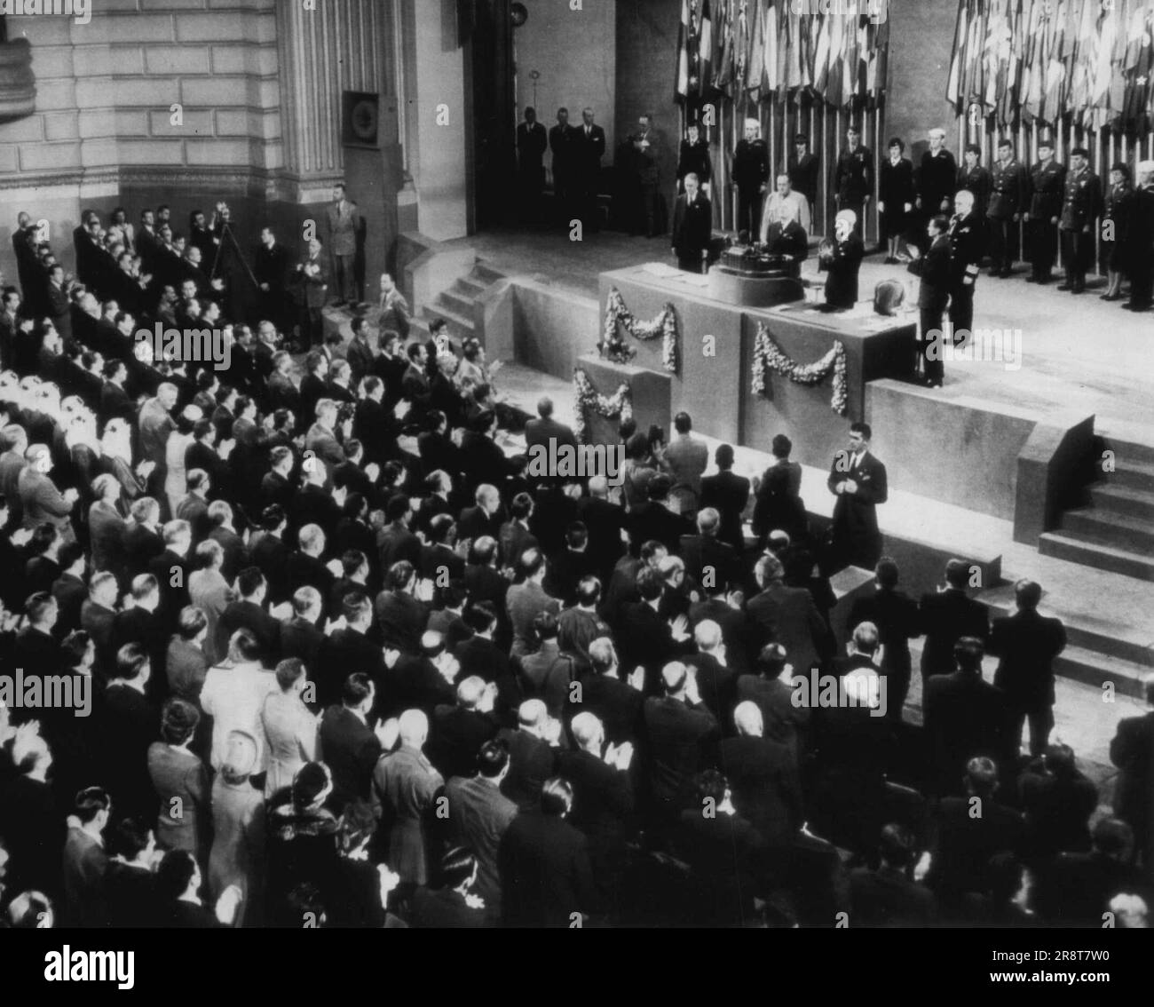 I delegati plaudono a Truman -- Conferenza delle Nazioni Unite i delegati si alzano in piedi e applaudono quando il Presidente Truman entra nel rostro per affrontare la sessione conclusiva della conferenza delle nove settimane. A sinistra di Truman c'è il segretario di Stato Stettinius. Giugno 26, 1945. (Foto di AP Wirephoto). Foto Stock